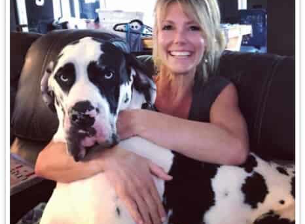 Blonde woman with dog smiling at camera
