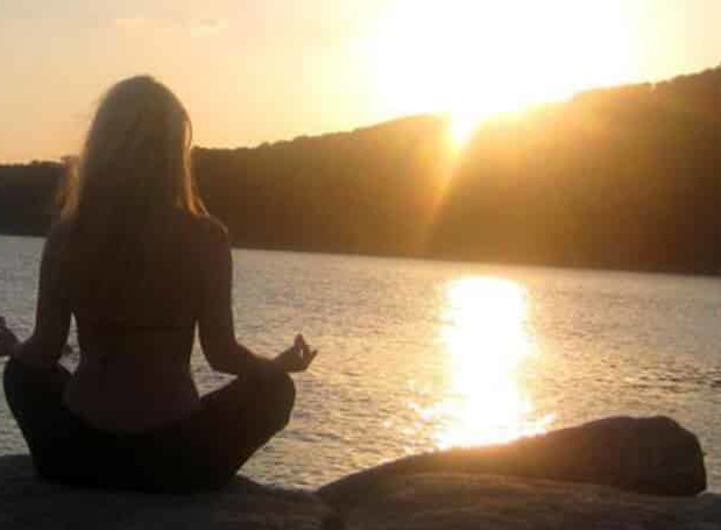Woman doing yoga by a lake