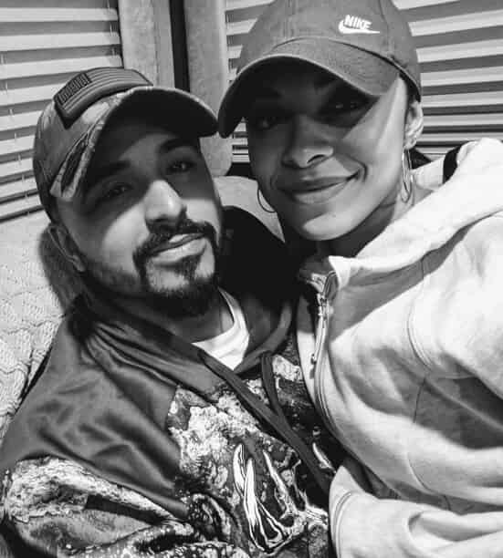 Husband and wife in black and white smiling at camera