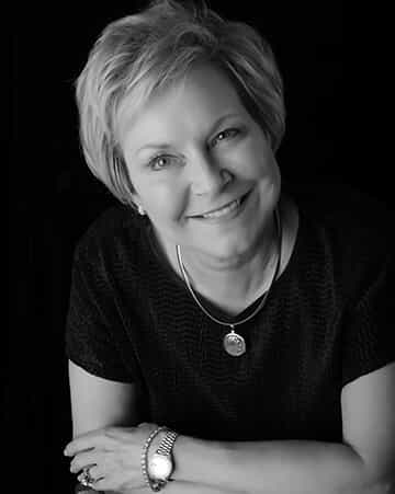 Black and white photo of a woman smiling at camera